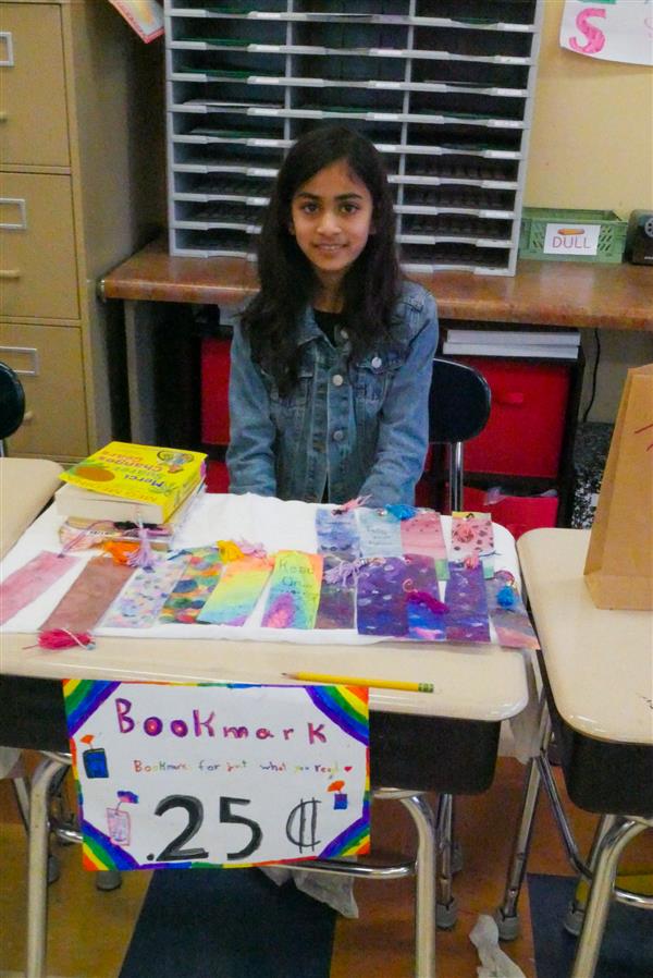 girl selling colorful bookmarks